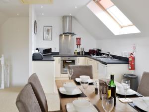 a dining room with a table and chairs and a kitchen at 32 Queens Court in Inchmarlo