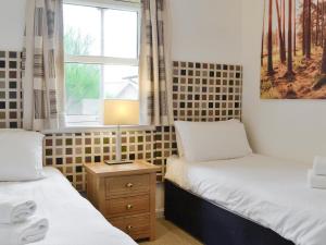 2 camas individuais num quarto com uma janela em 32 Queens Court em Inchmarlo