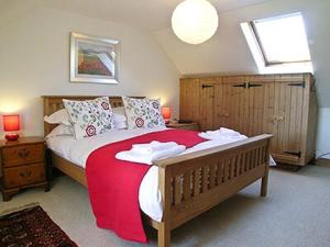 1 dormitorio con 1 cama grande con manta roja en Dalvuie Beag, en Connel
