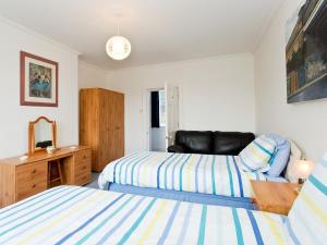 Un dormitorio con 2 camas y una silla. en Church Haven en Hunstanton