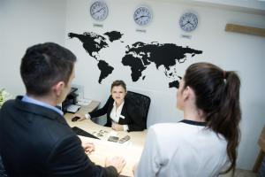 Gec في زابرشيتش: ثلاثة أشخاص يجلسون في مكتب مع خريطة العالم على الحائط