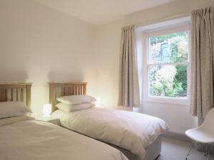 two beds in a room with a window at Beech Hill in Burneside