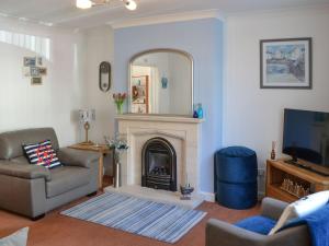 a living room with a fireplace and a mirror at Seaside Retreat in Amble