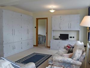 a living room with white cabinets and a couch at Bracelet Cottage in The Mumbles