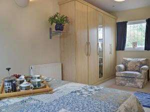 a bedroom with a bed and a cabinet and a chair at Bracelet Cottage in The Mumbles