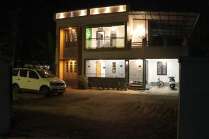 a white car parked in front of a house at night at Venitia Homestay in Alleppey