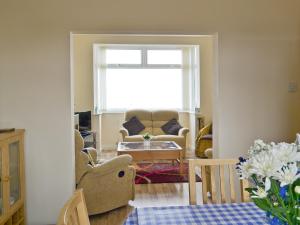 a living room with a couch and a table at Shell Seekers Cottage in Hornsea