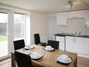a kitchen and dining room with a wooden table and chairs at Barn Cottage - E5560 in Winthorpe