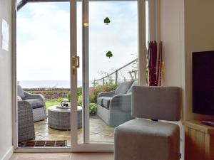 a living room with a sliding glass door with a view of the ocean at Making Waves in Anstruther