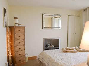 a bedroom with a bed and a dresser and a mirror at Making Waves in Anstruther