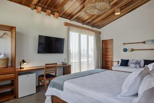 a bedroom with a bed and a desk and a television at Pousada Casa Zê - Praia do Preá in Prea +43 photos