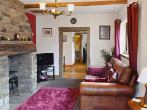 a living room with a couch and a fireplace at Marl Farm Cottage in Hayfield