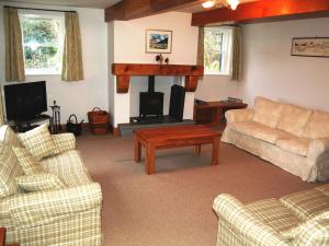 a living room with a couch and a fireplace at Gutherscale Lodge in Portinscale