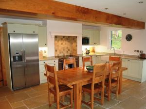 ポーティンズケールにあるGutherscale Lodgeのキッチン(木製テーブル、ステンレス製の冷蔵庫付)