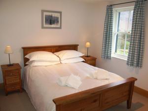ポーティンズケールにあるGutherscale Lodgeのベッドルーム1室(白いシーツと枕のベッド1台付)