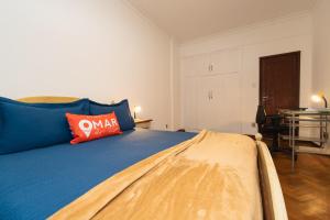 1 dormitorio con cama azul y almohada roja en 3Qts c/ Workstation e Garagem | NSC 1344/502, en Río de Janeiro