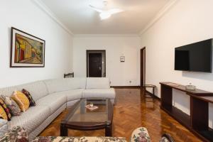 een woonkamer met een bank en een flatscreen-tv bij 3Qts c/ Workstation e Garagem | NSC 1344/502 in Rio de Janeiro