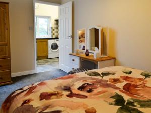 a bedroom with a bed and a kitchen with a washing machine at Doves Den in Gooseham