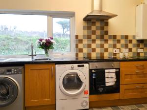 a kitchen with a washing machine and a sink at Doves Den in Gooseham