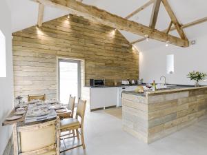 a kitchen with wooden walls and a table with chairs at Clawdd Y Parc in Llangibby