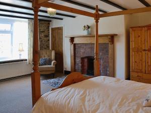 a bedroom with a bed and a fireplace at Conifers in South Molton