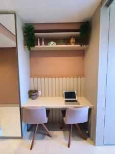 a desk with two chairs and a laptop on it at Flat novo no Eco Resort in Tamandaré