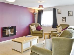 a living room with chairs and a fireplace at The Coach House - Or4 in Henfynyw Upper