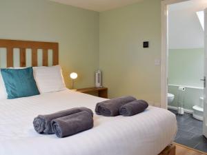 a bedroom with a bed with towels on it at The Coach House - Or4 in Henfynyw Upper