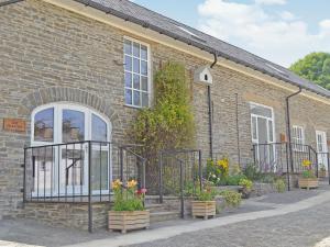 a brick building with a gate and flowers on it at The Coach House - Or4 in Henfynyw Upper