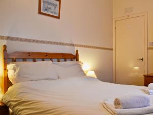 a bedroom with a white bed with towels on it at Macdonald Cottage in Balnald