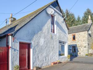 a white house with a red door at Macdonald Cottage in Balnald