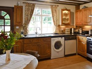 a kitchen with a washing machine and a sink at Y Bwthyn in Bala