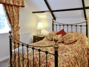 a bedroom with a bed and a lamp at Y Bwthyn in Bala