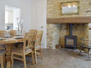 a dining room with a table and a fireplace at The Plough in Bampton