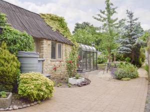 un jardín con una casa y un invernadero en The Plough en Bampton