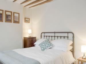 1 dormitorio con 1 cama con sábanas y almohadas blancas en The Plough en Bampton