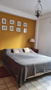 1 dormitorio con 1 cama grande y pared amarilla en DPTO BALCARCE en Salta