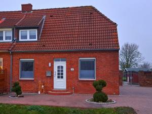 a red brick house with a white door at Deichstube-Greetsiel in Krummhörn