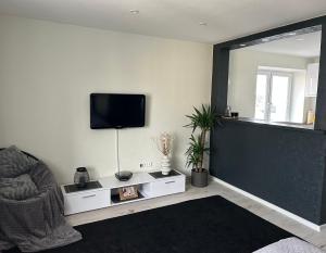 a living room with a flat screen tv on the wall at TEATRA Apartamenti in Liepāja