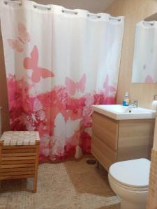 シエラネバダにあるESTUDIO EN ZONA BAJA y Garajeのバスルーム(トイレ、蝶が描かれたシャワーカーテン付)