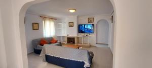 sala de estar con sofá y TV en Villa Bélgica en Gran Alacant, en Puerto Marino