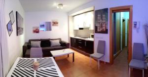 una sala de estar con un sofá y una mesa en ESTUDIO EN ZONA BAJA y Garaje Opcional, en Sierra Nevada