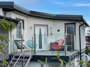 ein Haus mit zwei Stühlen und einer Terrasse in der Unterkunft Cozy Apartment next Outlet Center & Airport with Pool & Garden in Parndorf