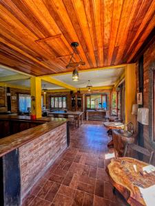 a dining room with a bar and tables at Pousada - Casa de Barro in Santo Antônio do Pinhal