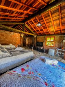 a room with two beds and a flat screen tv at Pousada - Casa de Barro in Santo Antônio do Pinhal