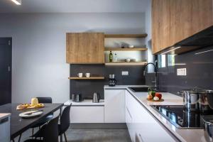 ピツイディアにあるVilla Pitsidia Hillsのキッチン(白いキャビネット、黒いカウンタートップ付)