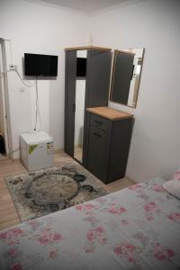 Schlafzimmer mit einem Bett, einer Kommode und einem Spiegel in der Unterkunft Little Center Apartament in Sibiu