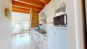 une cuisine avec des placards blancs et un comptoir dans l'établissement Villa la Petite Vallée, à Saint-Gilles-Croix-de-Vie