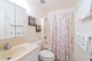 biała łazienka z toaletą i umywalką w obiekcie 19th Hole Condo w mieście Kahuku