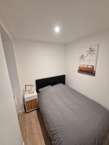 a bedroom with a bed and a table with a suitcase on the wall at Appartement Moderne Neuf F2 Centre ville in Valence